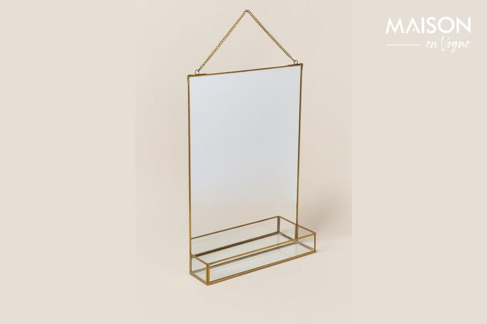 Uno specchio e la sua mensola evidenziata da una finitura dorata